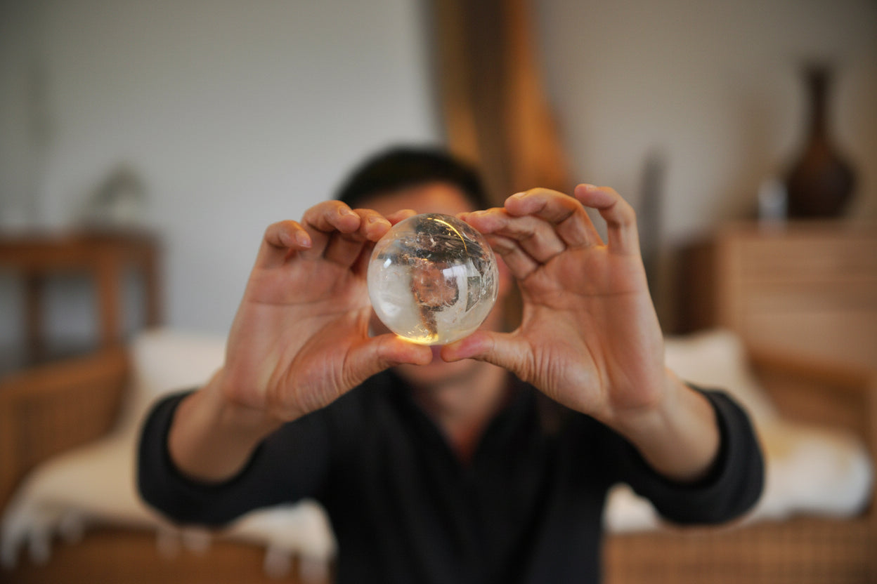 Person holding a crystal ball with a blurred background